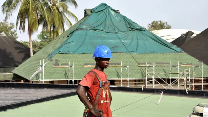 Un ouvrier travaillant à la réhabilitation du toit d'un batiment de l'institut polytechnique de Yamoussoukro